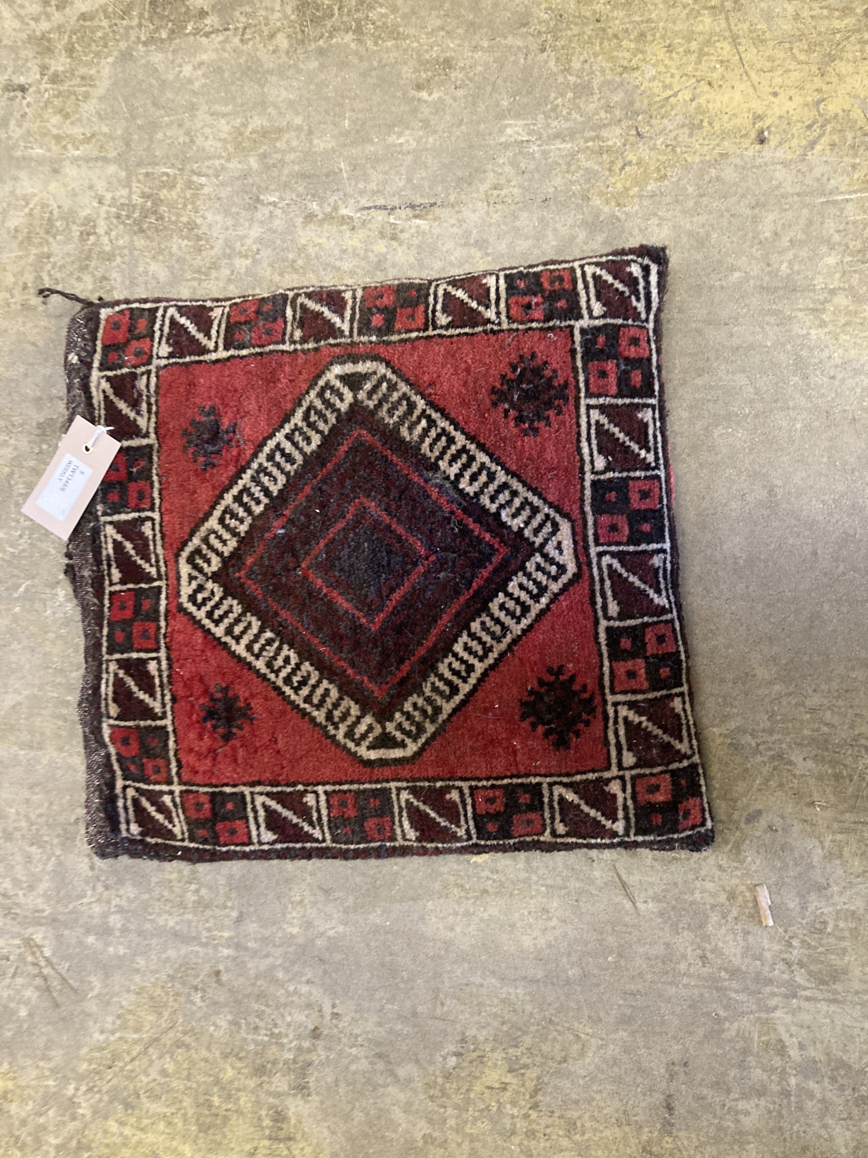 An Afghan red ground rug with stylised mihrab and iris motifs, a small Afghan rug and three carpet panel cushion covers, largest 200 x